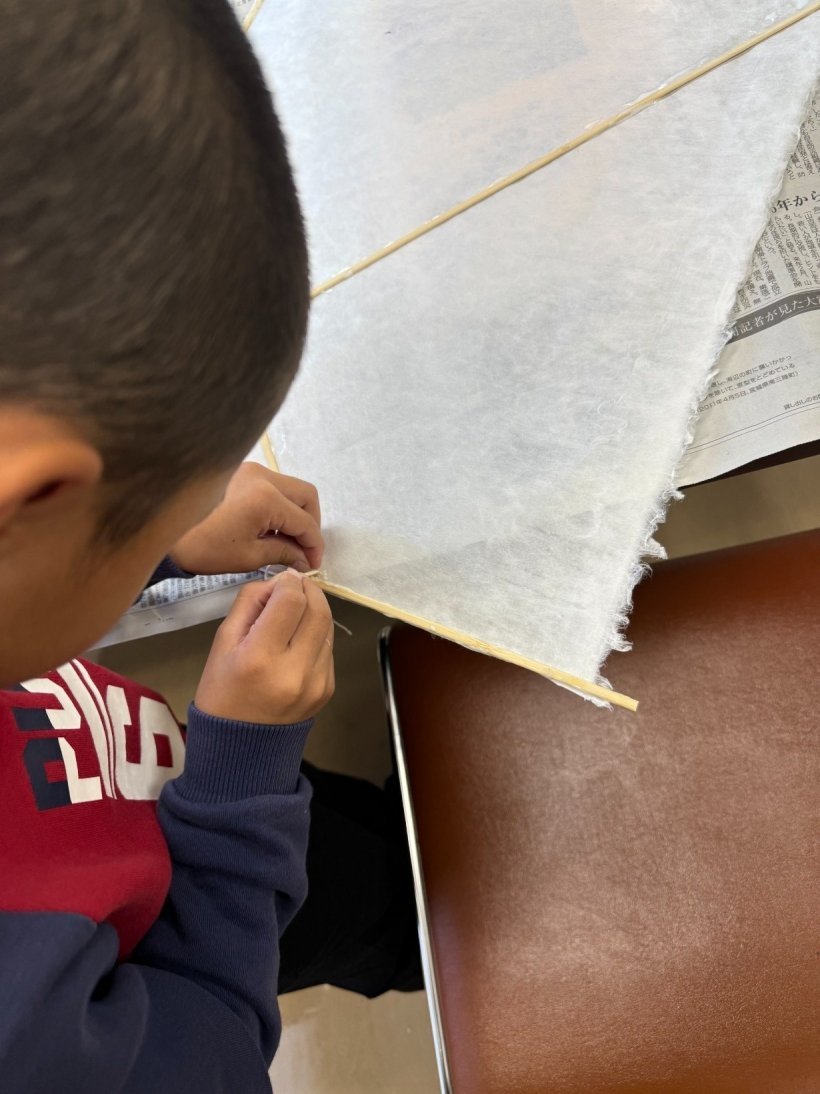 凧の竹を和紙と紐で結んでいる